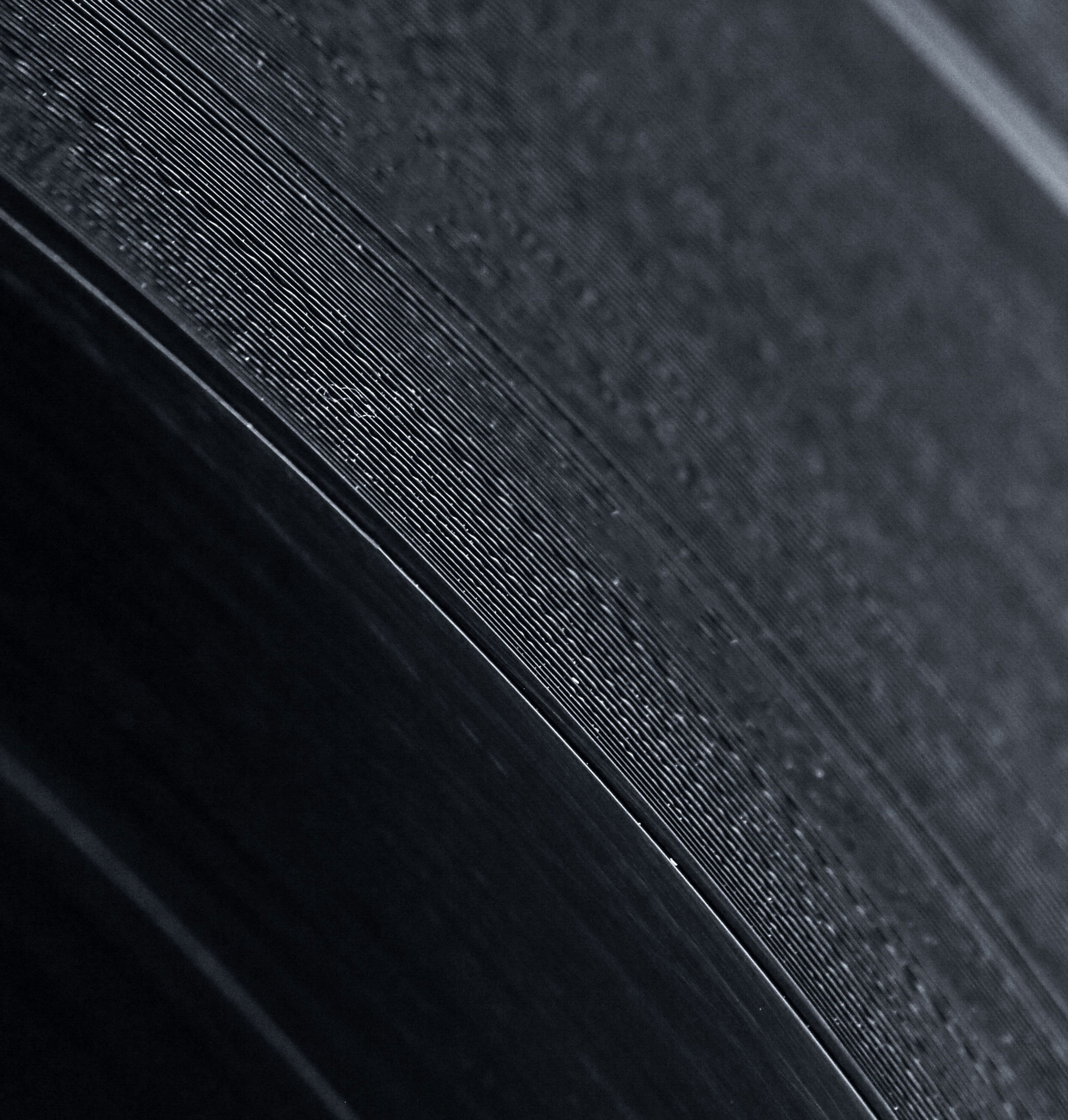 Close up photograph of black vinyl grooves.